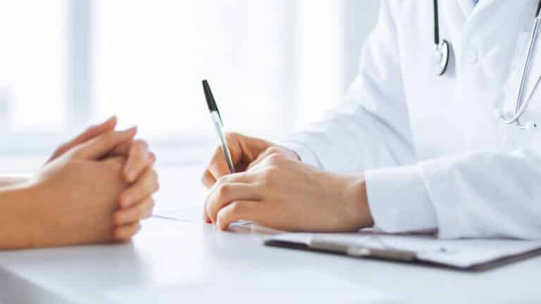 closeup photo of medical personnel writing in front of patient