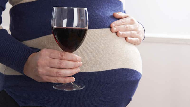 pregnant woman drinking glass of red wine