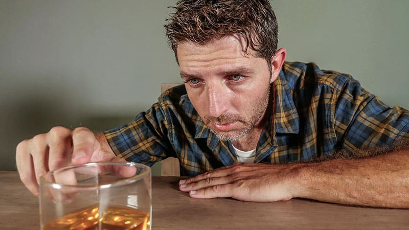 alcoholic man drinking whiskey glass intoxicated looking wasted