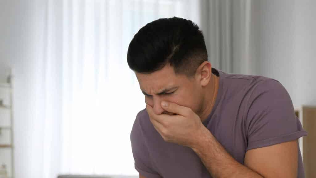 man suffering nausea at home