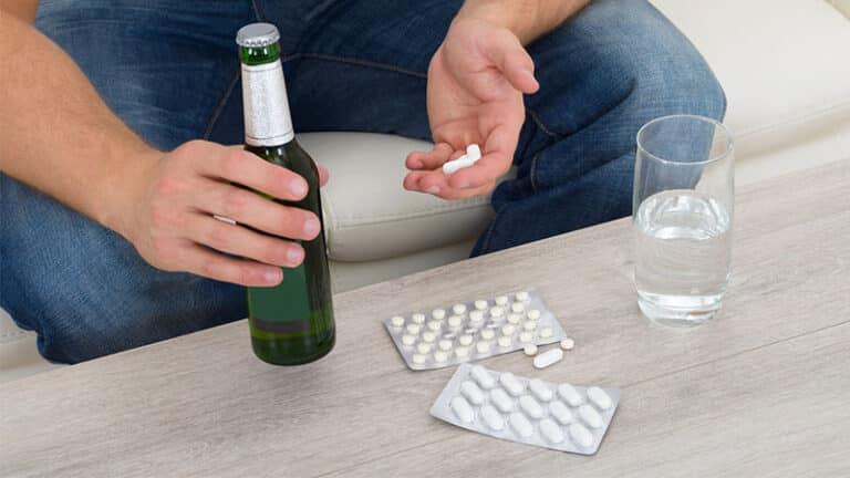 man with bottle and pills in hand