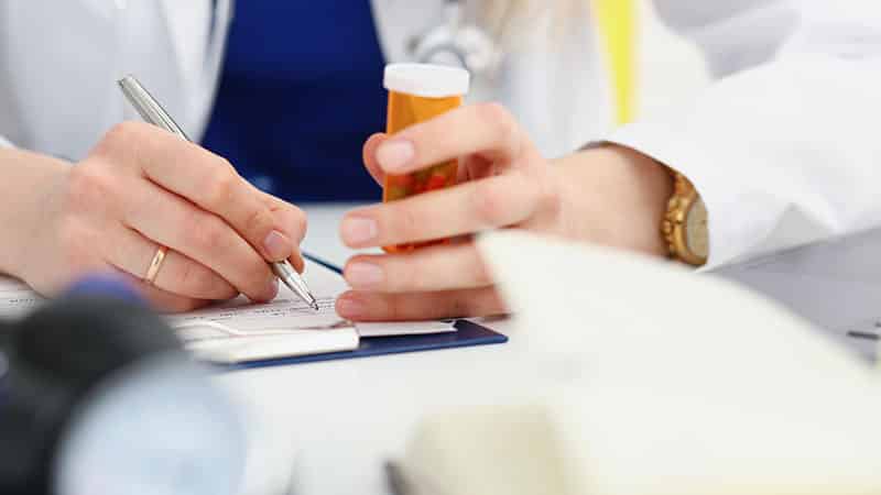 medicine doctor hand hold jar of pills