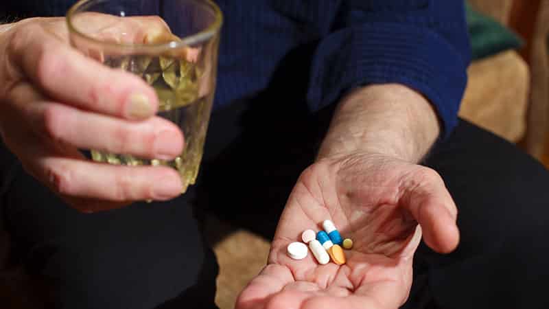 person holding alcohol and medication