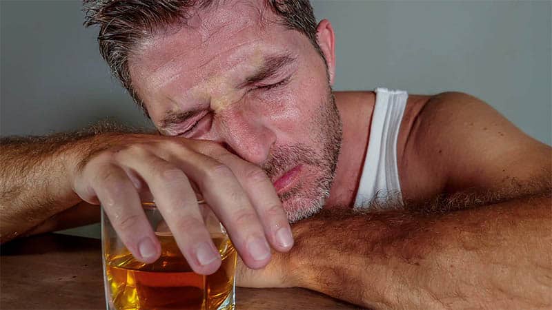Young wasted and depressed alcohol addict man