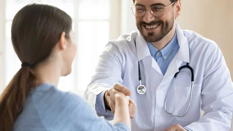 male doctor shaking hands with female patient