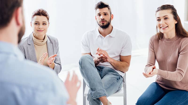 applauding while looking man group therapy session